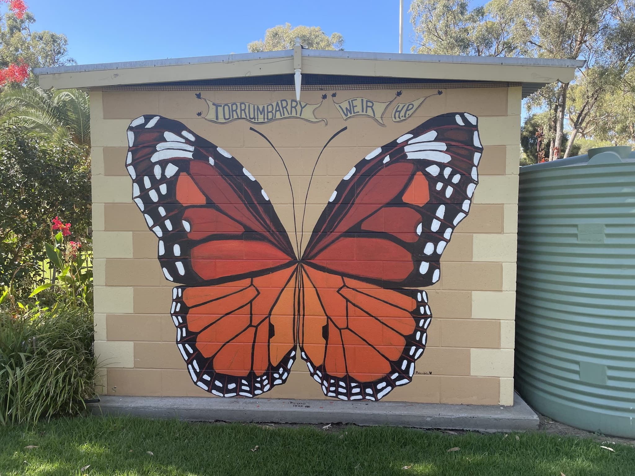 Large orange and black monarch butterfly mural on the amenities block wall at Torrumbarry Weir Holiday Park, Patho VIC